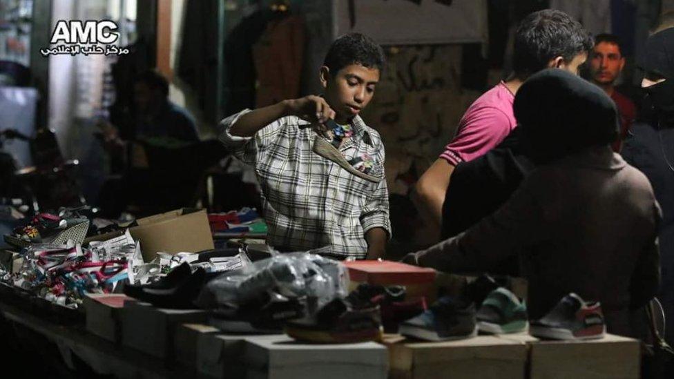 Picture of a child at a market buying shoes
