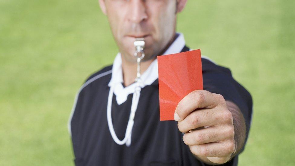Referee holding red card