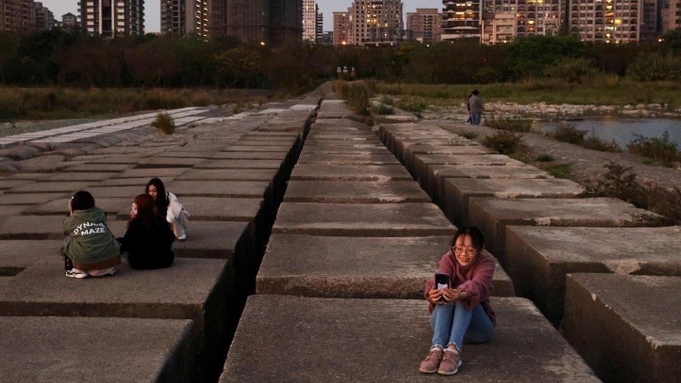 People take photos on the exposed riverbed of Taiwan"s Touqian river, a main water source for Hsinchu Science Park where major semiconductor companies are based, in Hsinchu, Taiwan during an island-wide drought, March 12, 2021.