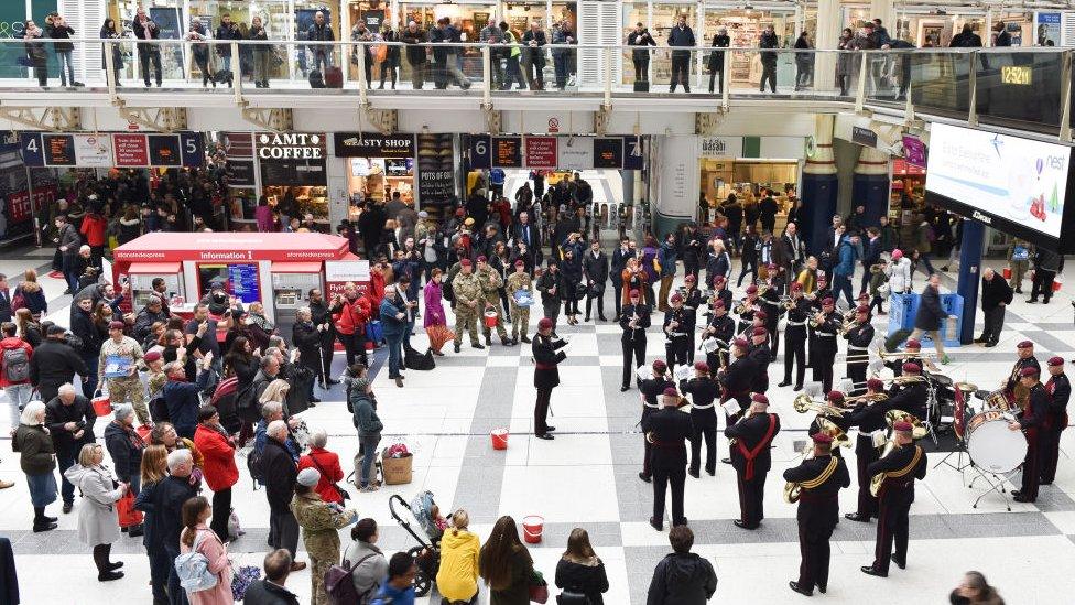 A Royal British Legion band plays to crowds on the concourse at Liverpool Street station