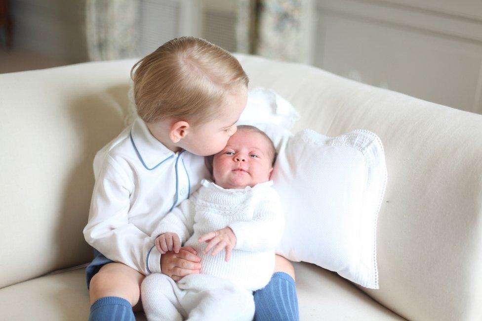 Prince George holding baby Princess Charlotte