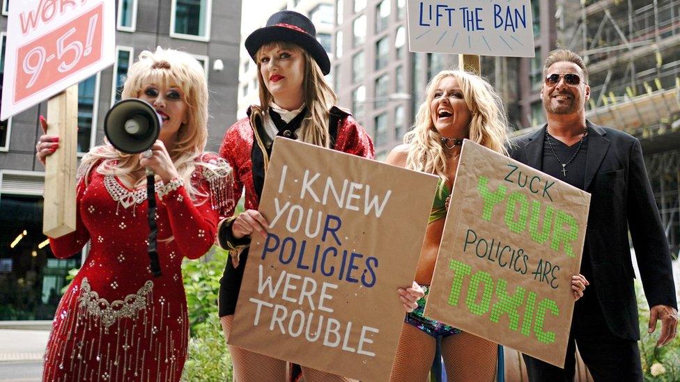 Dolly Parton, Taylor Swift, Britney Spears and George Michael impersonators, with the Taylor Swift tribute holding a sign reading "I knew your policies were trouble"