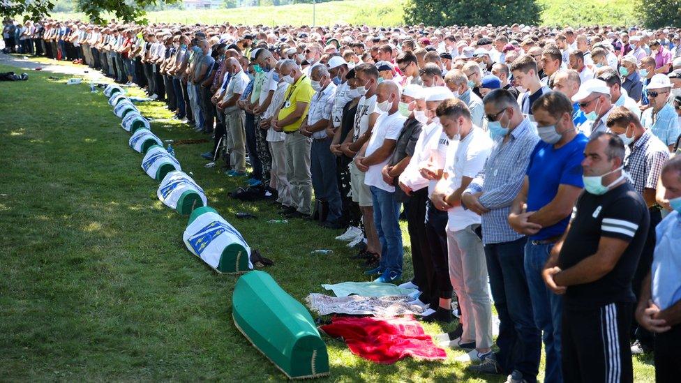 People praying at a memorial event