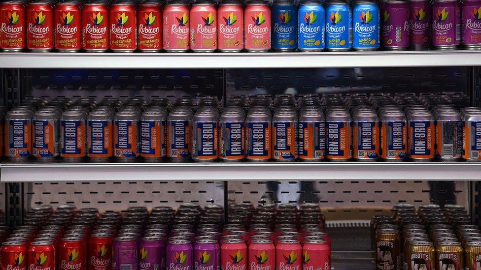 Fridge showing cans of soft drinks