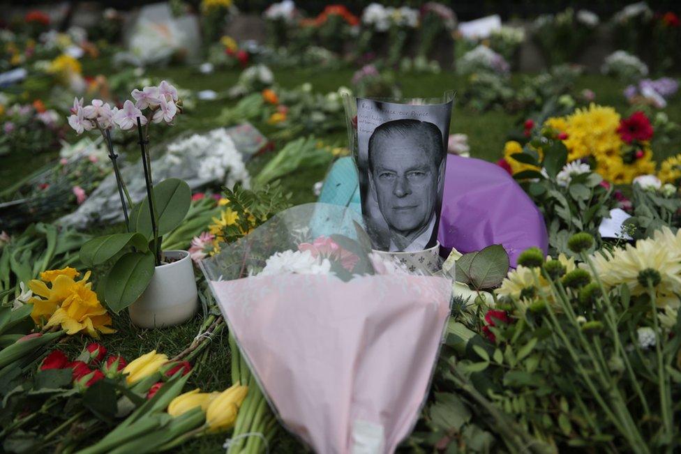 People leave flowers outside Windsor Castle, Berkshire, following the death of the Duke of Edinburgh