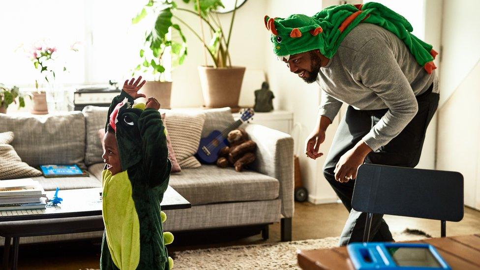 dad dressed as dinosaur chasing son dressed as dinosaur