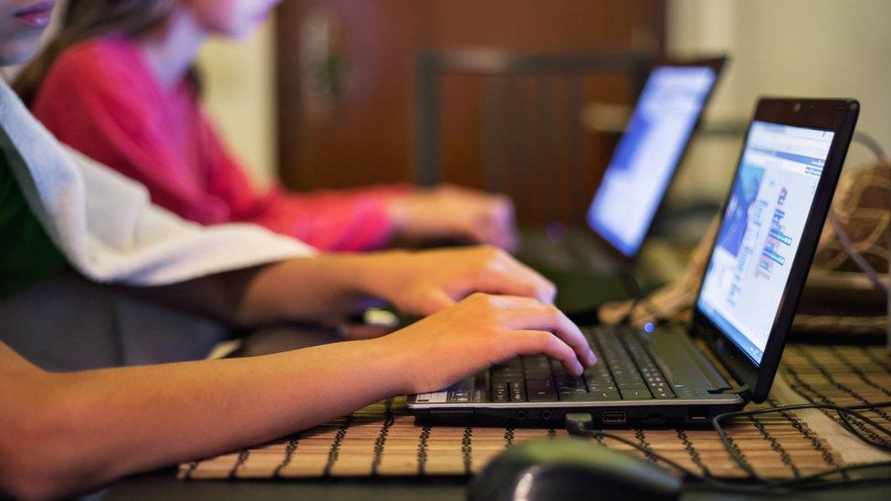 Stock image of children using laptops