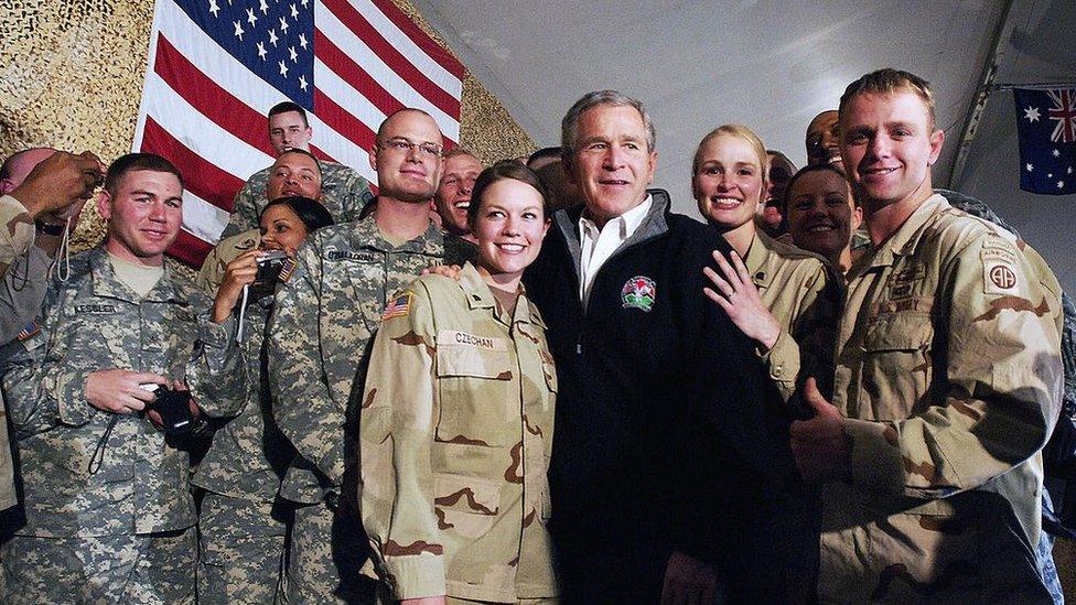 US President George W. Bush poses with American troops at Bagram Air Force Base, March 2006