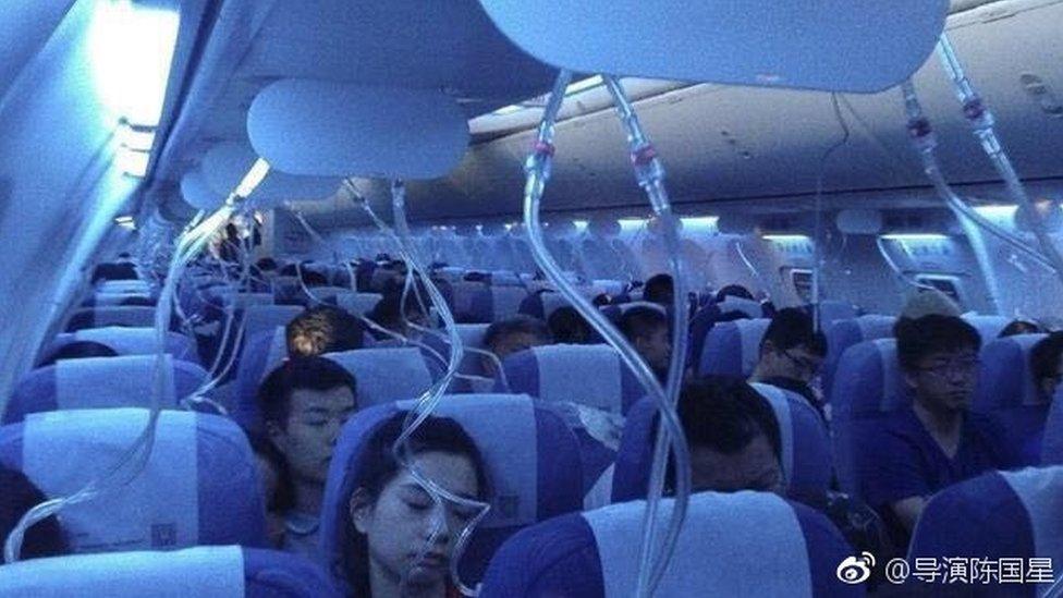 Aircraft passengers with oxygen masks dropped