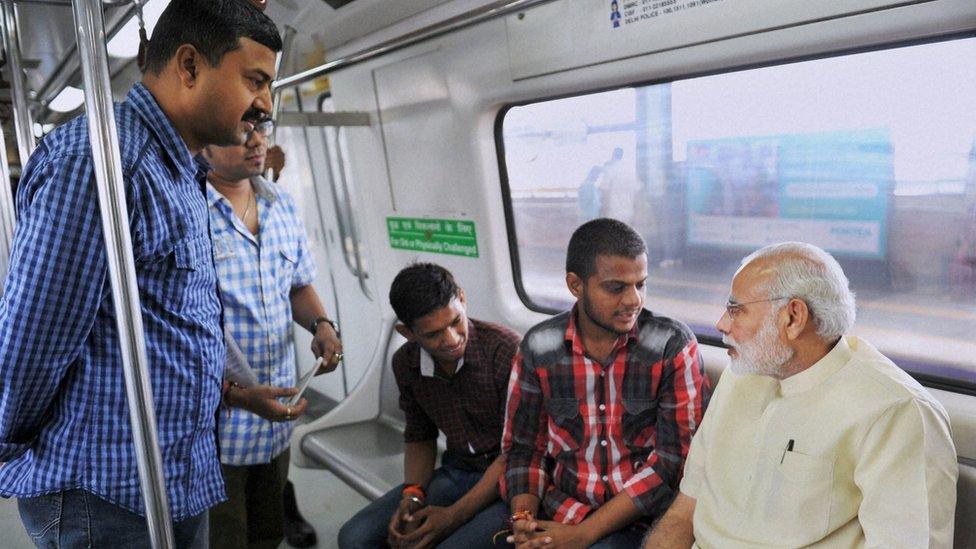 Prime Minister Narendra Modi talking to commuters in the Delhi metro