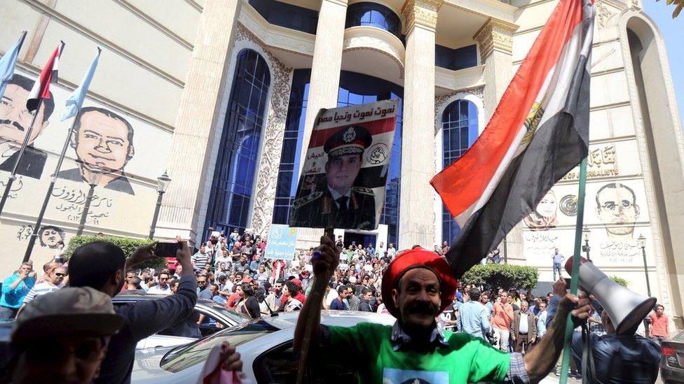 Supporter of President Abdul Fattah al-Sisi stands in front of anti-government protesters, outside the Egyptian journalists' union building in Cairo (15 April 2016)