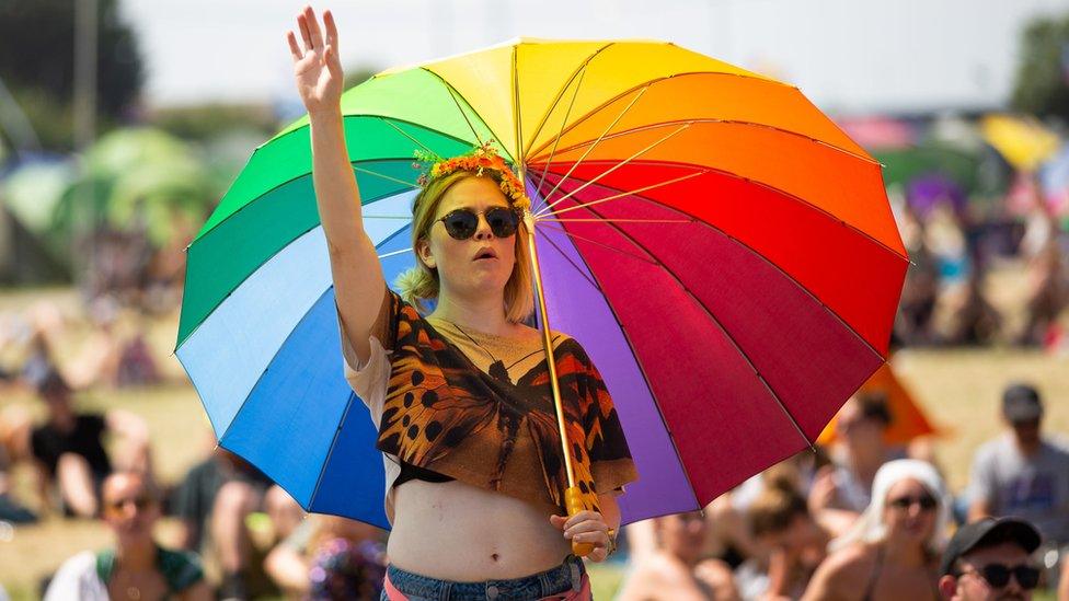 A festival goer in the sun at Glastonbury Festival at Worthy Farm in Pilton, Somerset.