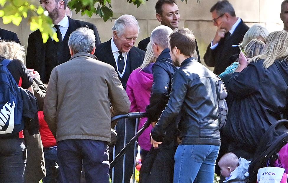 King Charles III talks to wellwishers in the garden area set aside for floral tributes outside the Palace of Holyroodhouse in Edinburgh on 12 September 2022