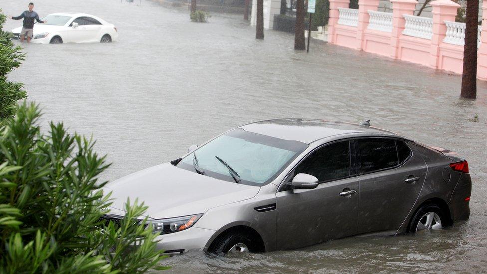 Partially submerged cars drift off the curb on East Battery Street as storm surge and rain water from Hurricane Matthew flood the southern-most tip of the city of Charleston, South Carolina October 8, 2016.