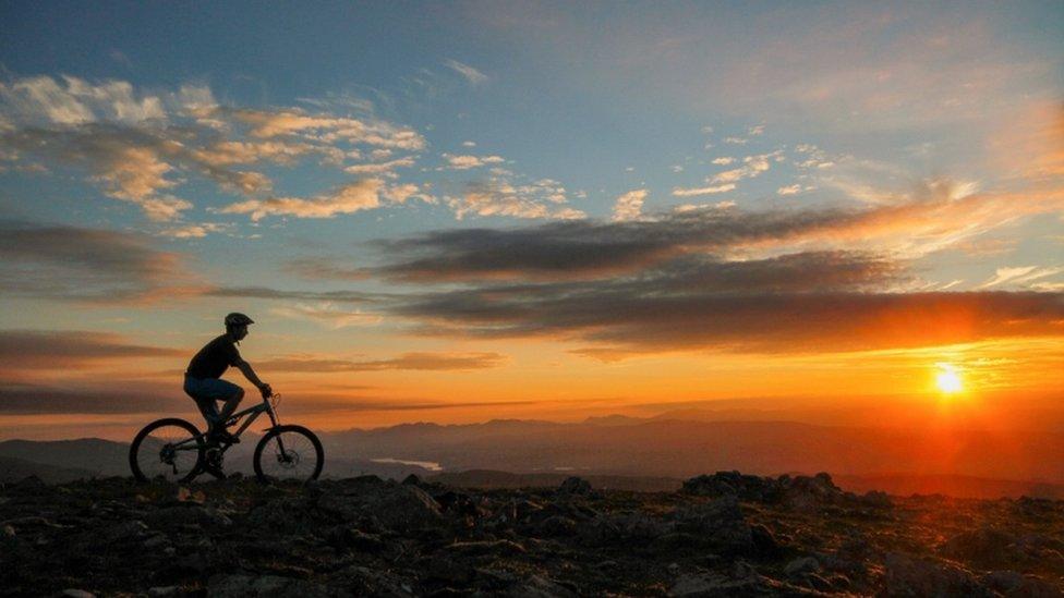 person-riding-bike-though-national-park-in-Scottish-Highlands.