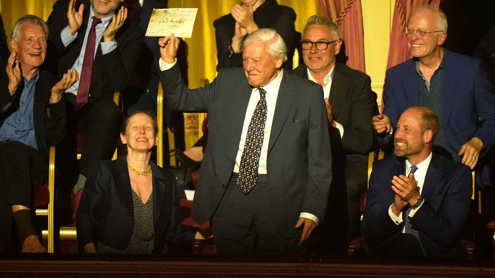 Sir David Attenborough duke mbajtur lart letrën e tij nga Mbreti në Sallën Mbretërore Albert, ndërsa është ulur pranë Princit William.
