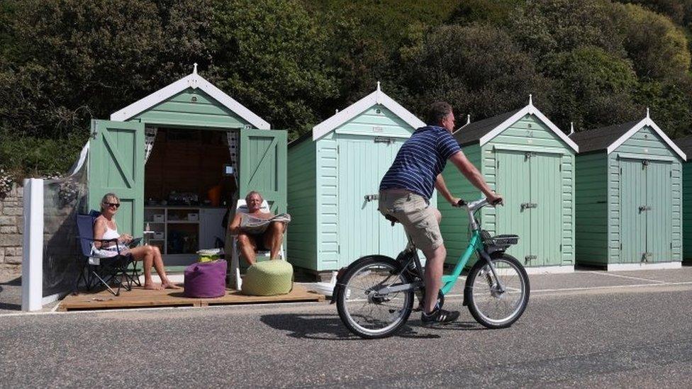 Rob and Sally Underhill sit outside their beach hut as they enjoy the hot weather at Bournemouth beach in Dorset on 20 May