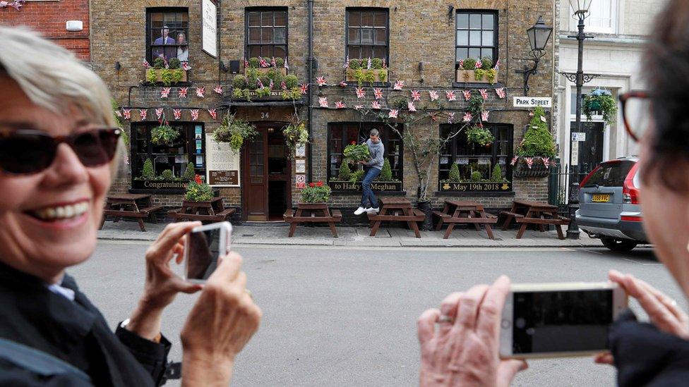 Flowers are hung outside a pub, covered in Union flag-themed bunting near Windsor Castle in Windsor