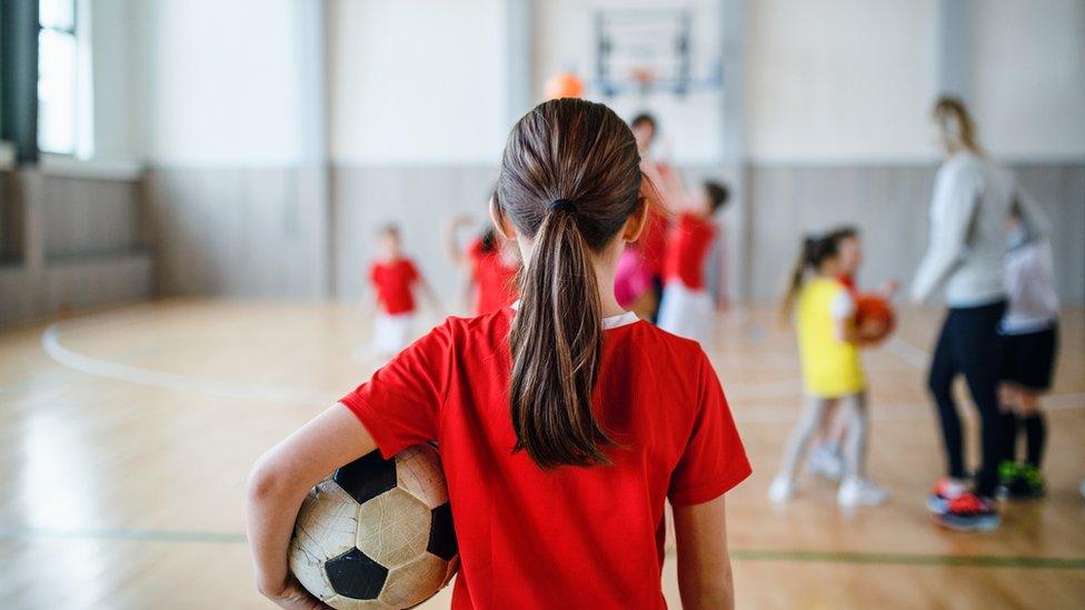 Young girl holds a football