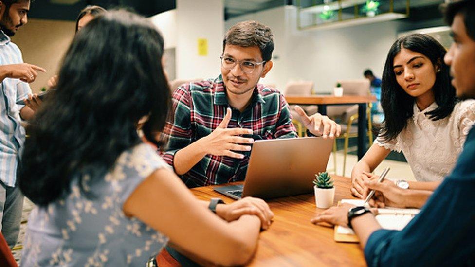 Group of young people discussing new venture set up in the co-working office