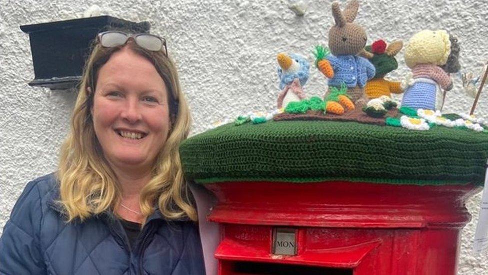 Clare Skeggs standing next to the post-box