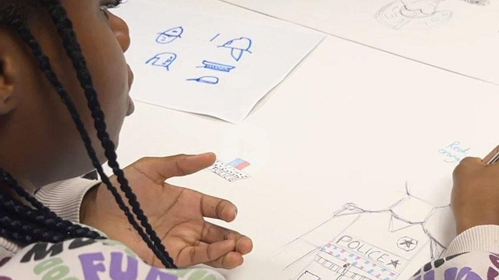 A young group member drawing a design