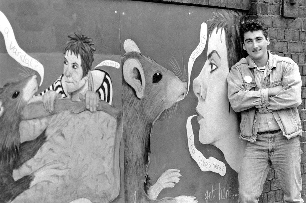 Artist Francis Gomila with his Alice in Smerick mural