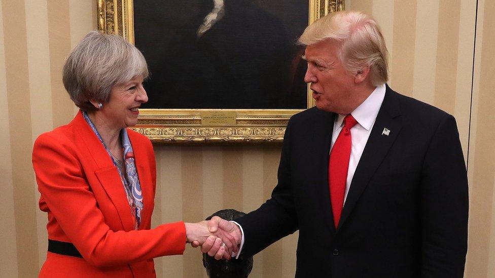 Mrs Theresa May and Mr Donald Trump smile and share a handshake at the Oval Office