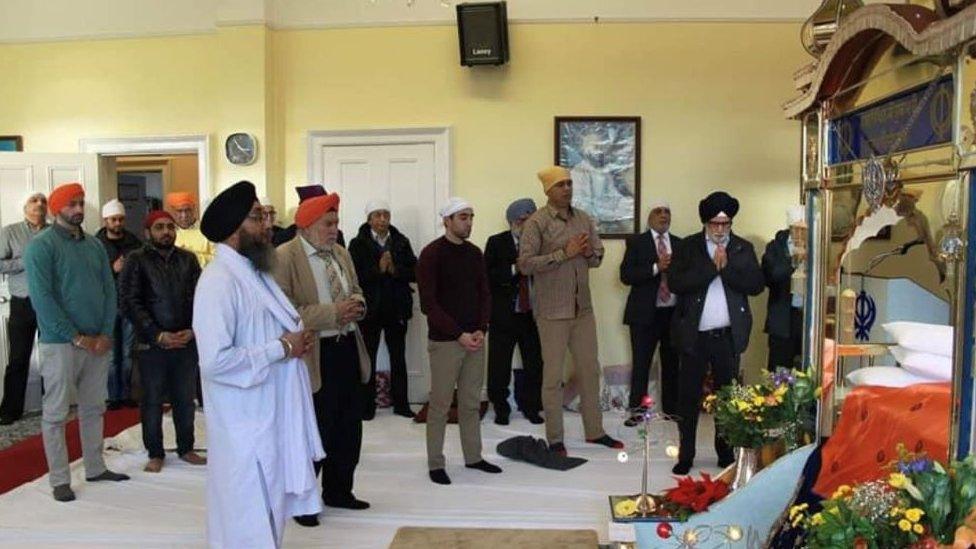 Men in prayer inside the Sikh temple in Derry prior to the fire