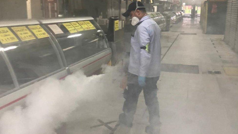 A man disinfects stalls at Plaza Minorista