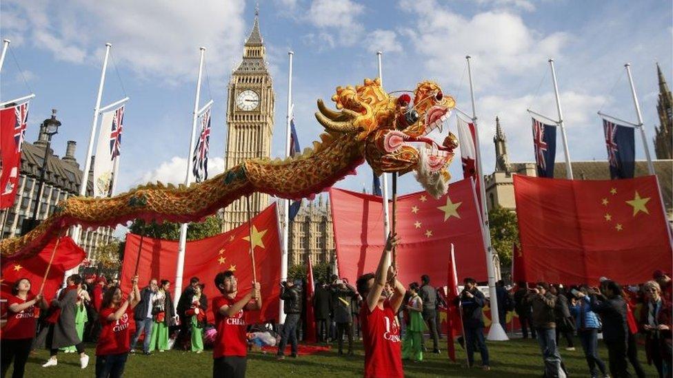 Supporters of China's President Xi Jinping perform opposite Big Ben in Parliament Square