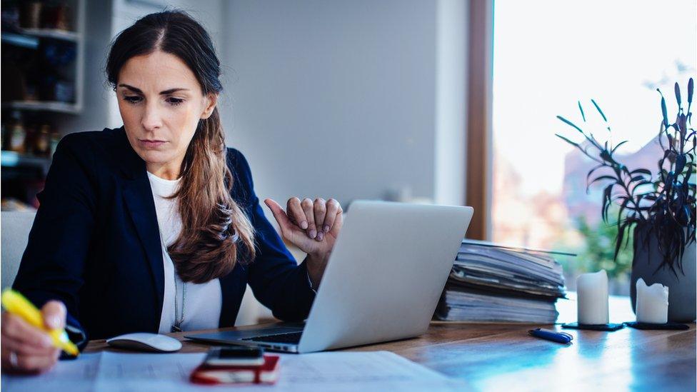 Businesswoman checking plan with laptop at home office.