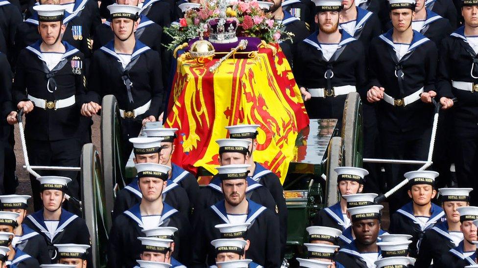 The Queen's coffin, borne on the State Gun Carriage of the Royal Navy and adorned with the Imperial State Crown, Orb and Sceptre, travels along The Mall on September 19, 2022