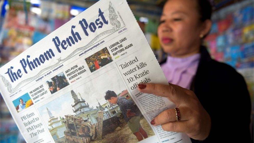 A Cambodian vendor reads the Phnom Penh Post newspaper at her newstand in Phnom Penh on May 7, 2018. The newspaper hailed as Cambodia"s last independent English daily has been sold to a Malaysian investor with apparent business links to premier Hun Sen, rattling a journalist community that has been battered by the strongman ahead of elections.