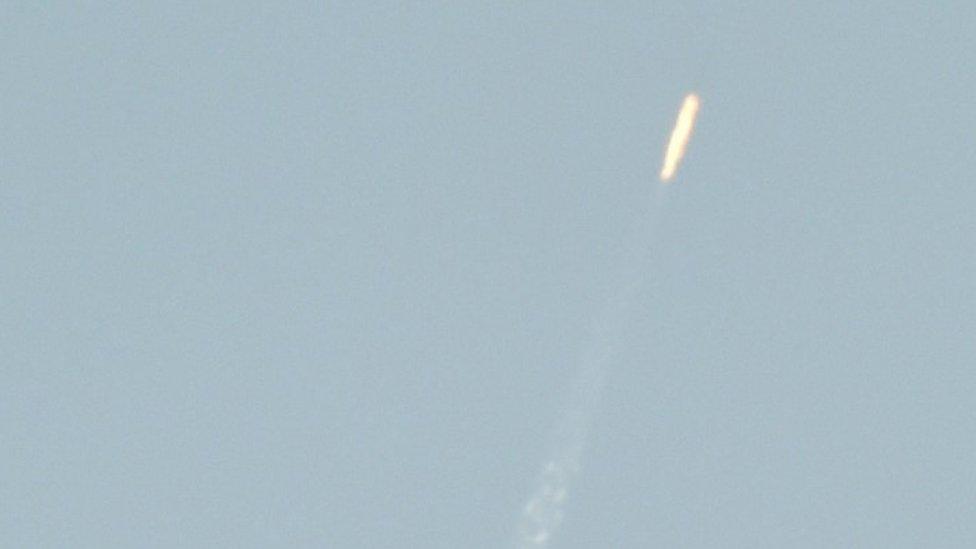 A flying object soars into the air above North Korean territory as seen from the Chinese border city of Dandong, 7 February