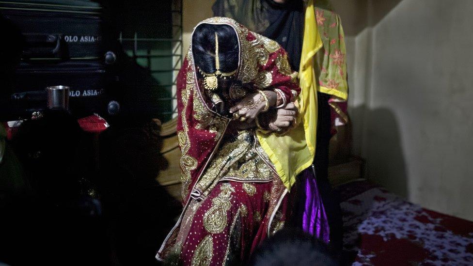 File photo: A relative tries to drag a 15-year-old onto a bed to pose for photographs on the day of her wedding to a 32-year-old man, 20 August 2015 in Manikganj, Bangladesh