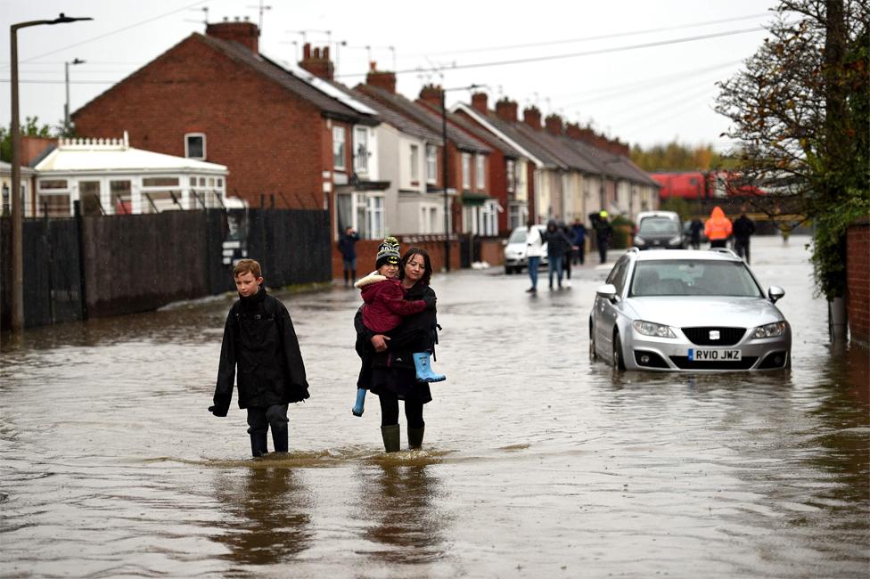 Residents walk through flood water