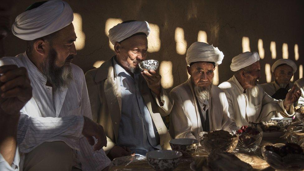 Uyghur men gather for a holiday meal during the Corban Festival on 13 September, 2016 in Turpan County, in the far western Xinjiang province, China