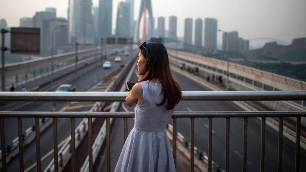 A young lady enjoys the view of the Yangtze river in Chongqing on May 31, 2017