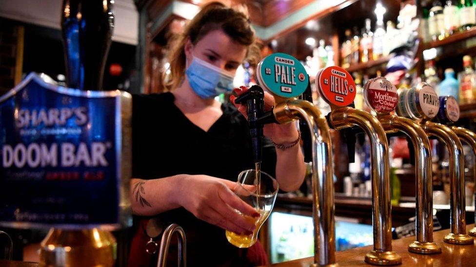 A woman pours a pint in a pub in Mayfair, London