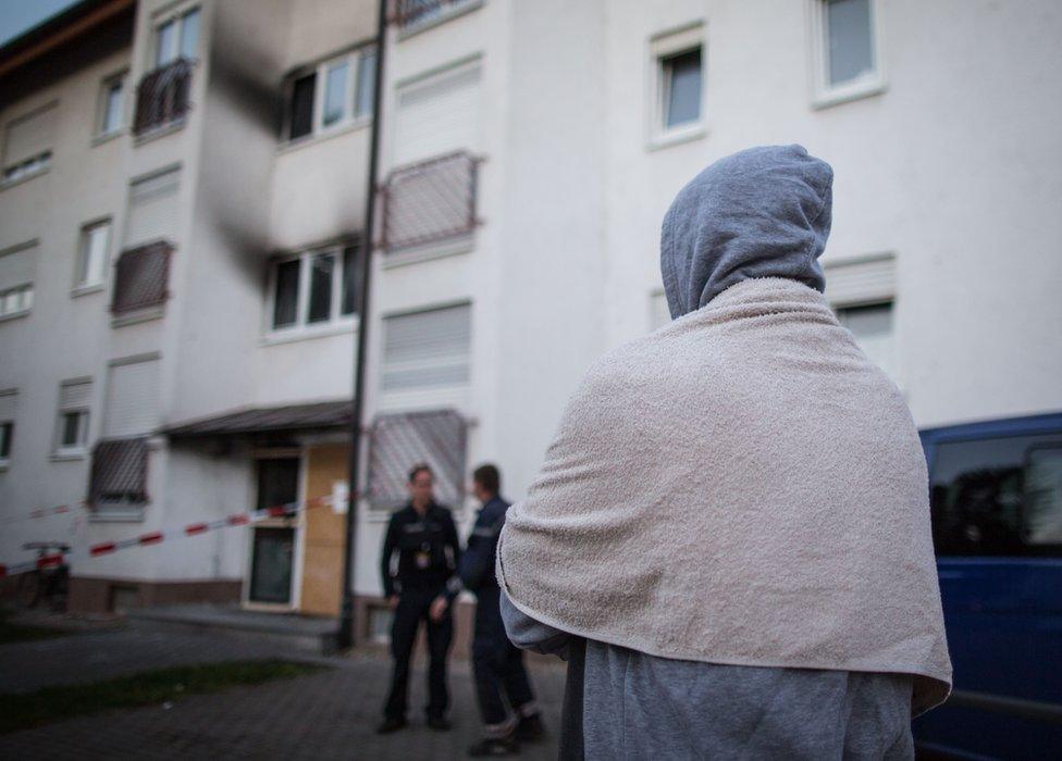 An asylum seeker stands outside a shelter for near Frankfurt Germany