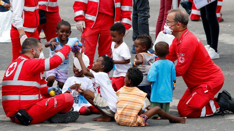 Italian Red Cross staff play with children after they disembarked the Italian coast guard vessel "Diciotti" at the port of Catania, Italy on 13 June 2018