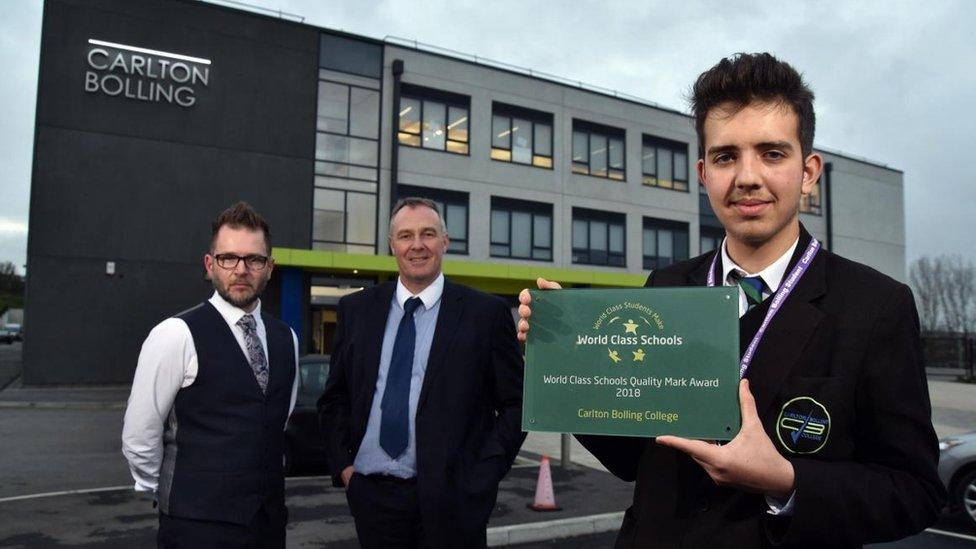 Pupil James Gibson from Year 11 holds the award given to Carlton Bolling by the World Class Schools Quality Mark flanked by Assitant Head Tony Moon and Head Adrian kneeshaw.