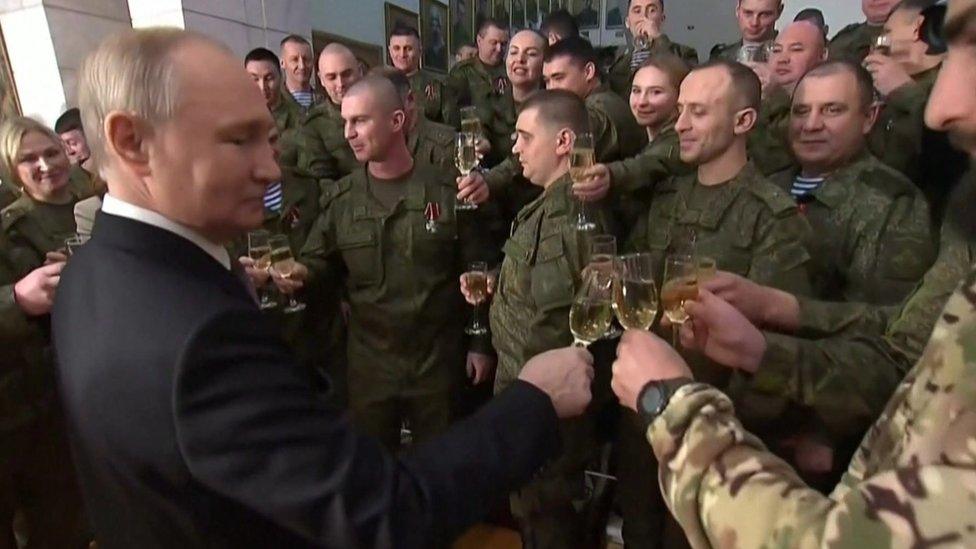 President Putin raising a toast with people in military uniforms