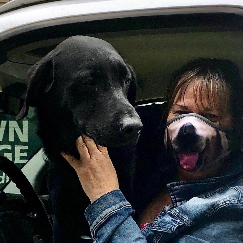 Sunni seen with a dog, wearing a dog mask, in one of the vans