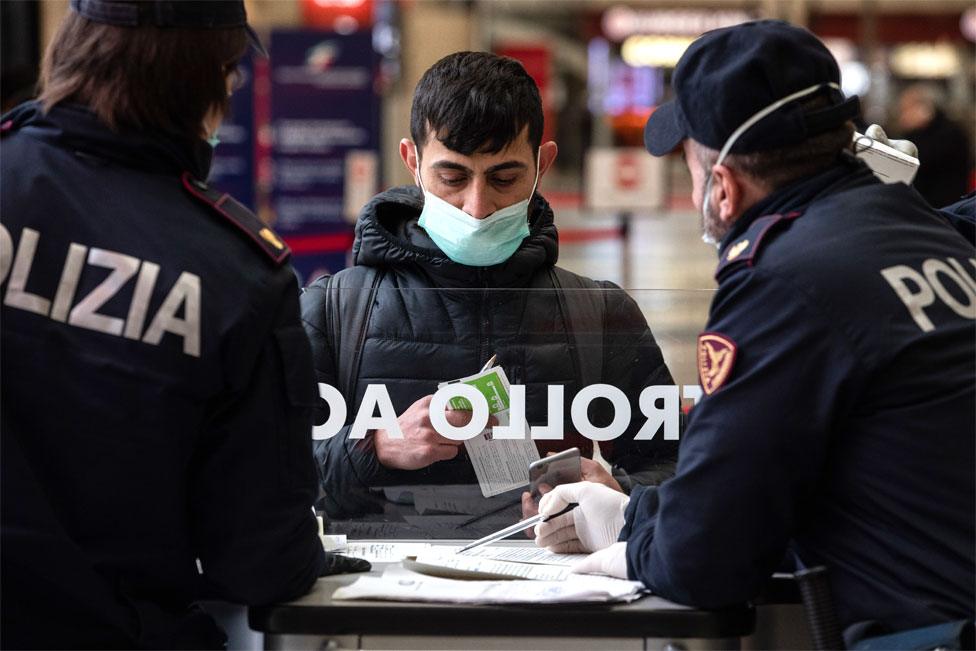 Italian State Police officers speak to man