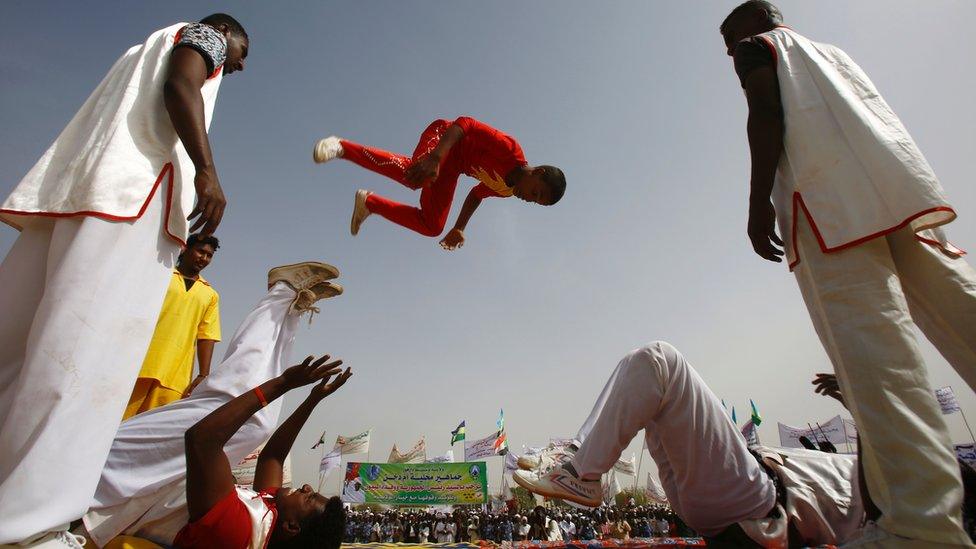 Acrobats - one in the air - perform at a rally in Zalingei in Darfur, Sudan - Sunday 3 April 2016
