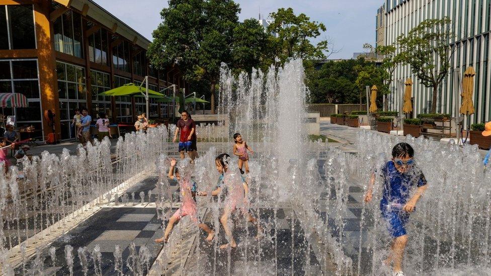 Children play in a public fountain on a hot day in Shanghai, China, 13 July 2022