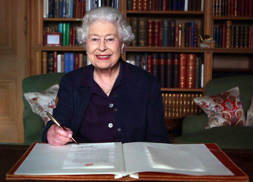 The Queen signing a document