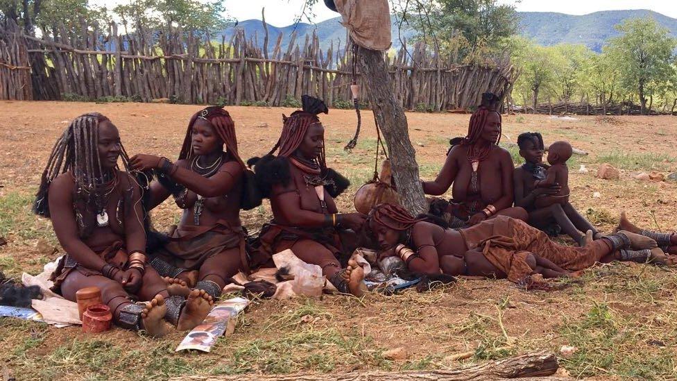 Himba women doing their hair in Omuhoro village, Kunene region, Namibia